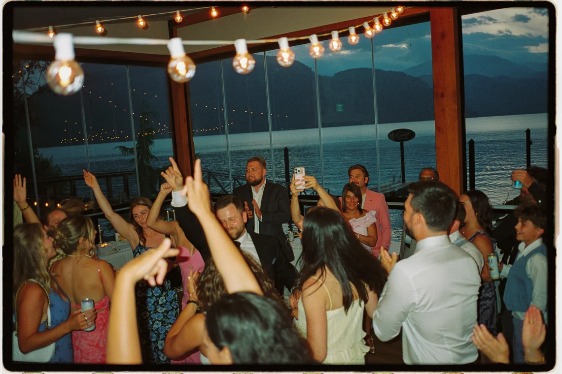 The same Fraser Valley wedding earlier in the evening, sunset still in the windows, as guests fill the reception floor.